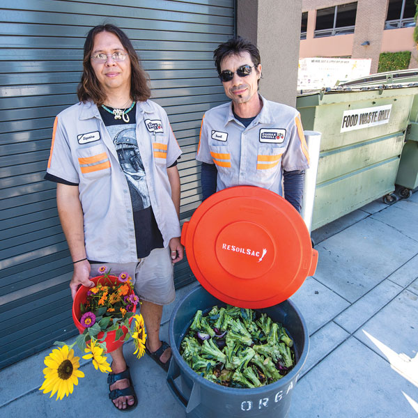 two employees of ReSoil showing off their collected green waste