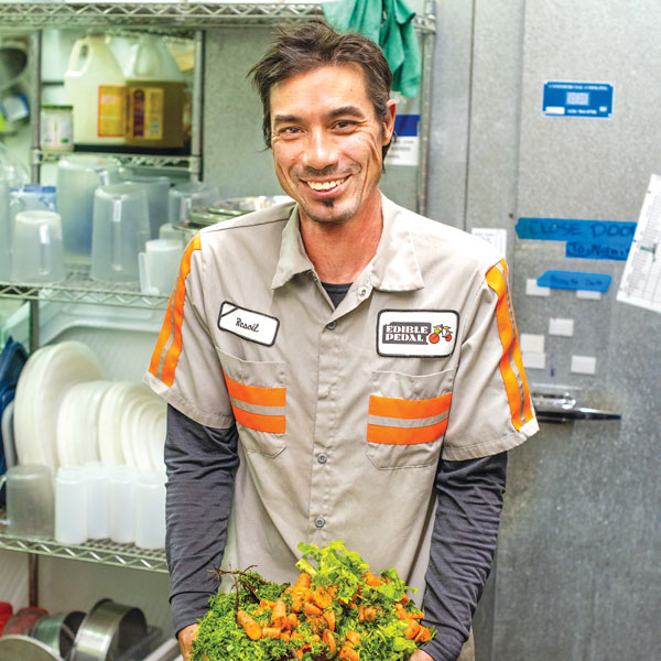 Resoil employee smiling and holding green waste