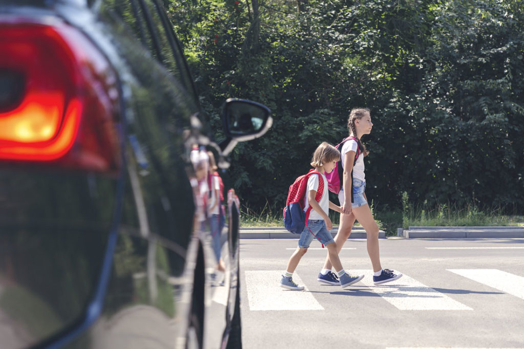 Two children walking in crosswalk